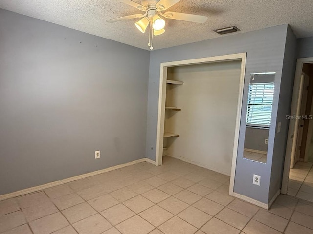 10811 Candlin Ct, Riverview, FL 33578 - unfurnished bedroom featuring a textured ceiling, light tile patterned flooring, a closet, ceiling fan, and baseboards