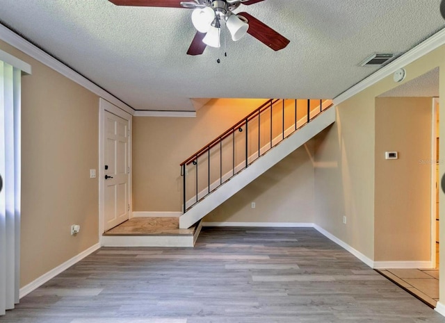 1877 Pine Cone Cir, Clearwater, FL 33760 - foyer entrance with wood finished floors, a ceiling fan, ornamental molding, stairs, and a textured ceiling