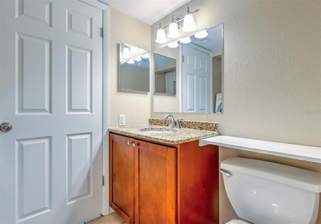 1877 Pine Cone Cir, Clearwater, FL 33760 - bathroom featuring a textured wall, vanity, and toilet