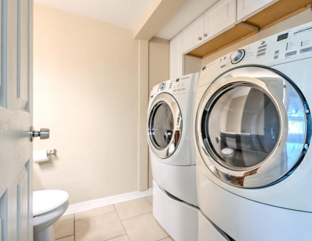1877 Pine Cone Cir, Clearwater, FL 33760 - washroom featuring washer and clothes dryer, light tile patterned flooring, and baseboards