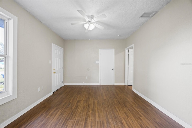 4804 N 18th St, Tampa, FL 33610 - spare room featuring plenty of natural light, dark wood-style floors, a ceiling fan, a textured ceiling, and baseboards