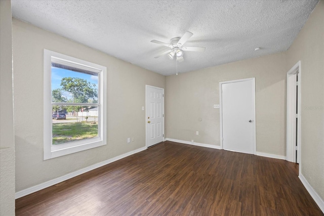 4804 N 18th St, Tampa, FL 33610 - empty room with dark wood finished floors, ceiling fan, baseboards, and a textured ceiling