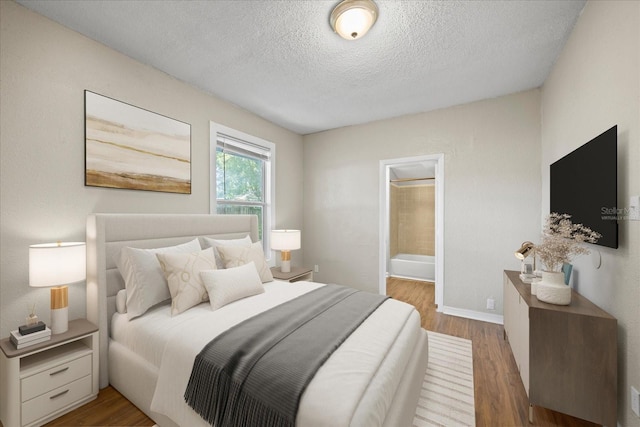 4804 N 18th St, Tampa, FL 33610 - bedroom with a textured ceiling, wood finished floors, baseboards, and ensuite bath