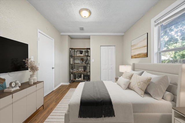4804 N 18th St, Tampa, FL 33610 - bedroom with dark wood-type flooring, a textured ceiling, and a closet