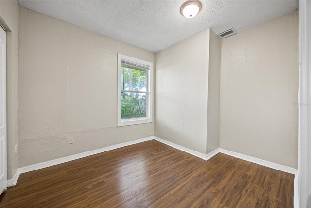 4804 N 18th St, Tampa, FL 33610 - empty room featuring wood finished floors, a textured ceiling, and baseboards