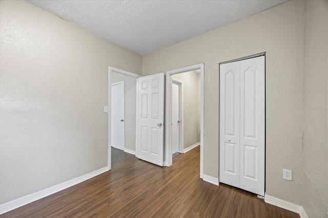4804 N 18th St, Tampa, FL 33610 - unfurnished bedroom with dark wood-style flooring, baseboards, a closet, and a textured ceiling