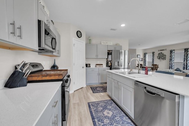 14643 Brumby Ridge Ave, Lithia, FL 33547 - kitchen featuring stainless steel appliances, a sink, light wood-style flooring, open floor plan, and recessed lighting