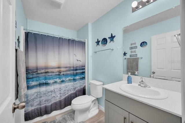 14643 Brumby Ridge Ave, Lithia, FL 33547 - bathroom featuring vanity, toilet, a textured ceiling, wood finished floors, and baseboards