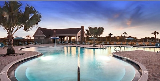 14643 Brumby Ridge Ave, Lithia, FL 33547 - pool at dusk featuring a patio area and a community pool