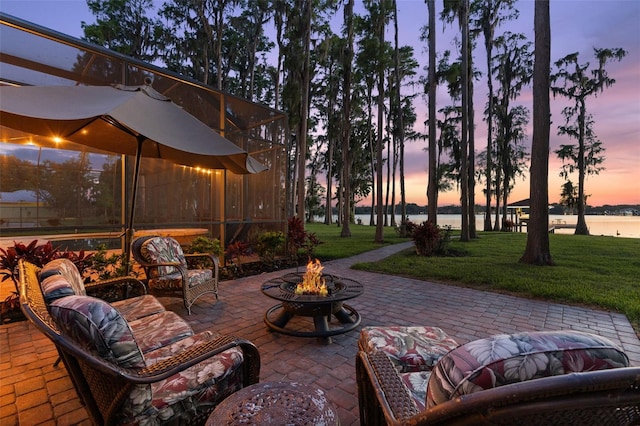 18258 Wayne Rd, Odessa, FL 33556 - patio terrace at dusk with an outdoor fire pit, a patio, a water view, and a lawn