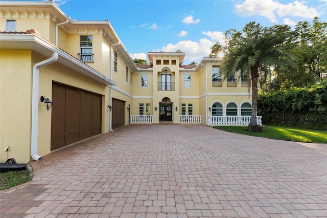 18258 Wayne Rd, Odessa, FL 33556 - mediterranean / spanish-style home featuring stucco siding, decorative driveway, and a garage