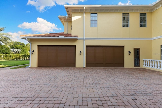 18258 Wayne Rd, Odessa, FL 33556 - view of front of home featuring stucco siding, decorative driveway, and a garage