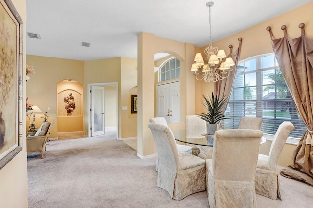 1212 Baycove Ln, Lutz, FL 33549 - dining room featuring a chandelier, light colored carpet, arched walkways, and baseboards