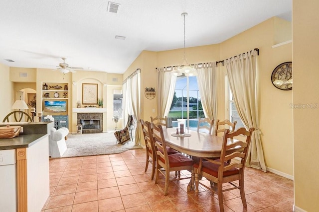 1212 Baycove Ln, Lutz, FL 33549 - dining space with ceiling fan, light tile patterned flooring, a tiled fireplace, and built in features