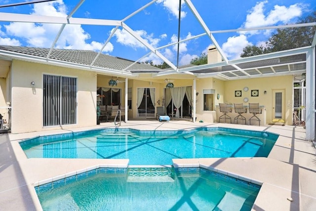 1212 Baycove Ln, Lutz, FL 33549 - view of swimming pool with a patio area, glass enclosure, a pool with connected hot tub, and an outdoor kitchen