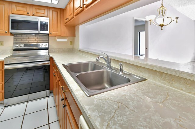 2593 Countryside Blvd Unit 7305, Clearwater, FL 33761 - kitchen with appliances with stainless steel finishes, a sink, light tile patterned flooring, light countertops, and a chandelier