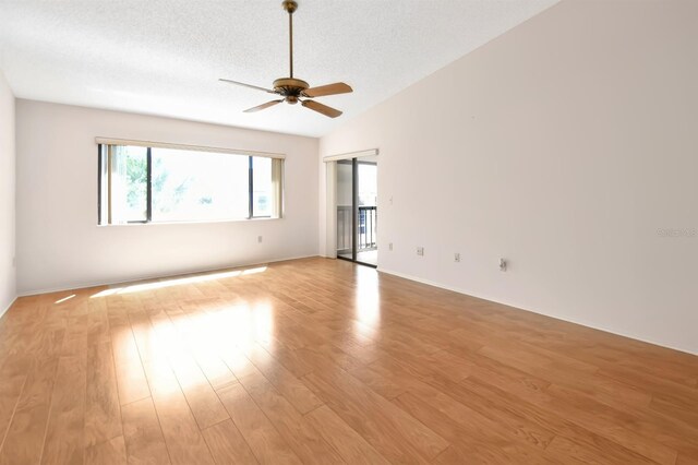 2593 Countryside Blvd Unit 7305, Clearwater, FL 33761 - spare room featuring ceiling fan, light wood-type flooring, a textured ceiling, lofted ceiling, and baseboards