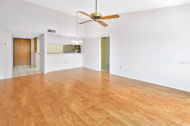 2593 Countryside Blvd Unit 7305, Clearwater, FL 33761 - unfurnished room featuring a ceiling fan, a chandelier, wood finished floors, and a towering ceiling