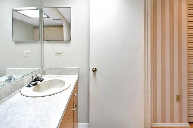 2593 Countryside Blvd Unit 7305, Clearwater, FL 33761 - bathroom featuring wallpapered walls, vanity, and baseboards
