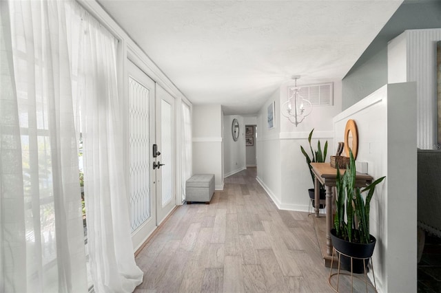 60 Lakeview Ct, Palm Harbor, FL 34683 - hallway with a chandelier, light wood-type flooring, and baseboards