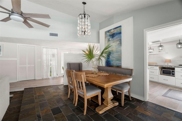 60 Lakeview Ct, Palm Harbor, FL 34683 - dining area with ceiling fan, a chandelier, and dark stone finish floors