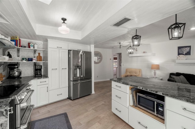 60 Lakeview Ct, Palm Harbor, FL 34683 - kitchen featuring stainless steel appliances, white cabinets, light wood-type flooring, and dark stone counters
