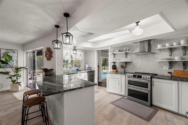 60 Lakeview Ct, Palm Harbor, FL 34683 - kitchen featuring appliances with stainless steel finishes, wall chimney range hood, open shelves, tasteful backsplash, and dark stone counters