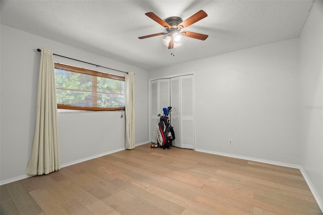 60 Lakeview Ct, Palm Harbor, FL 34683 - unfurnished bedroom with light wood-type flooring, baseboards, ceiling fan, and a closet