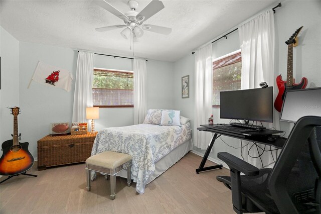 60 Lakeview Ct, Palm Harbor, FL 34683 - bedroom with light wood finished floors, ceiling fan, and a textured ceiling