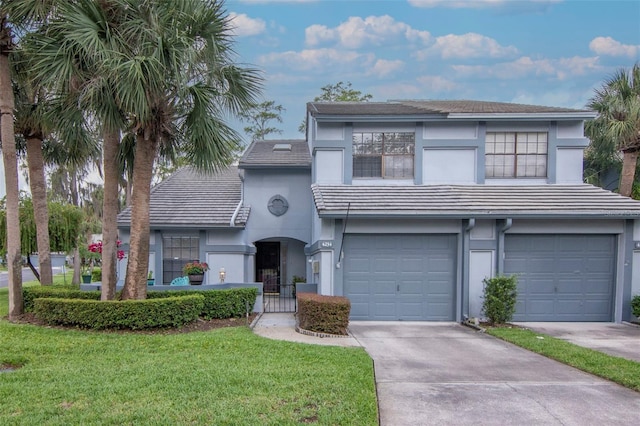 4234 Brentwood Park Cir, Tampa, FL 33624 - view of front of house featuring stucco siding, driveway, a front yard, an attached garage, and a tiled roof