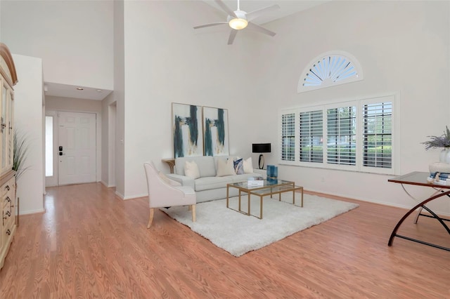 4234 Brentwood Park Cir, Tampa, FL 33624 - living area featuring a towering ceiling, light wood finished floors, a ceiling fan, and baseboards