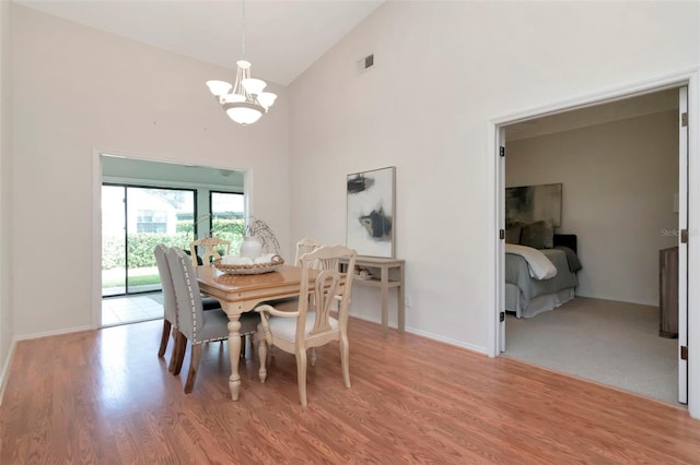 4234 Brentwood Park Cir, Tampa, FL 33624 - dining space featuring a chandelier, high vaulted ceiling, light wood finished floors, and baseboards