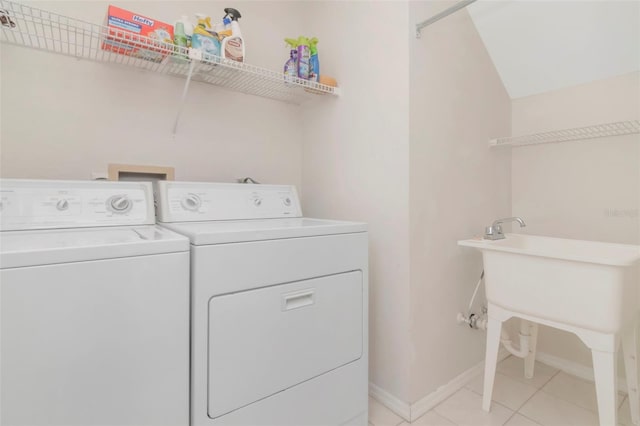 4234 Brentwood Park Cir, Tampa, FL 33624 - washroom with washing machine and dryer, light tile patterned flooring, and baseboards