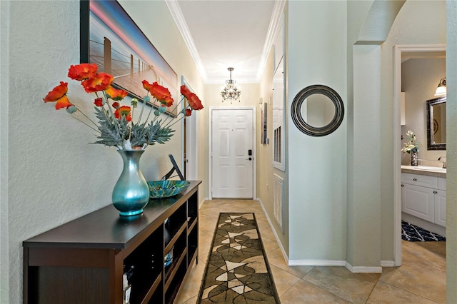 2773 Via Cipriani Unit 1310A, Clearwater, FL 33764 - hall with crown molding, a sink, a chandelier, light tile patterned floors, and baseboards