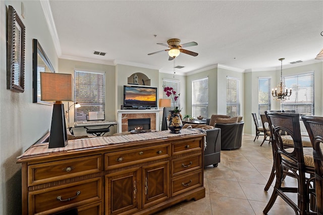 2773 Via Cipriani Unit 1310A, Clearwater, FL 33764 - living room with ceiling fan, a fireplace, a chandelier, ornamental molding, and light tile patterned floors