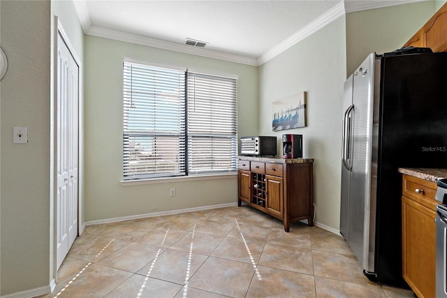 2773 Via Cipriani Unit 1310A, Clearwater, FL 33764 - kitchen with freestanding refrigerator, ornamental molding, brown cabinets, and light tile patterned flooring