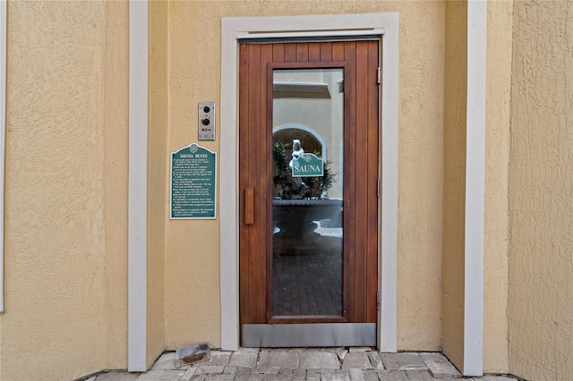 2773 Via Cipriani Unit 1310A, Clearwater, FL 33764 - view of exterior entry featuring stucco siding and elevator