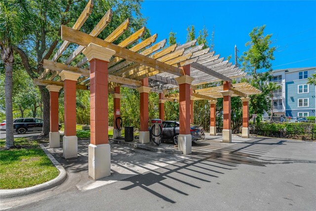 2773 Via Cipriani Unit 1310A, Clearwater, FL 33764 - view of community with a pergola and uncovered parking