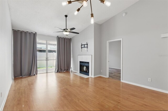 16109 Rambling Vine Dr E, Tampa, FL 33624 - unfurnished living room featuring light wood-style floors, a ceiling fan, a fireplace with flush hearth, a chandelier, and baseboards
