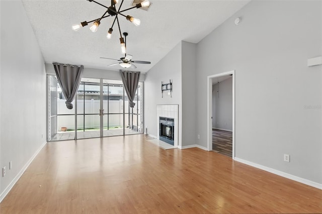 16109 Rambling Vine Dr E, Tampa, FL 33624 - unfurnished living room with a chandelier, baseboards, a fireplace, wood finished floors, and lofted ceiling