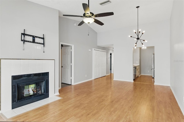 16109 Rambling Vine Dr E, Tampa, FL 33624 - unfurnished living room with high vaulted ceiling, a tile fireplace, ceiling fan, light wood finished floors, and baseboards