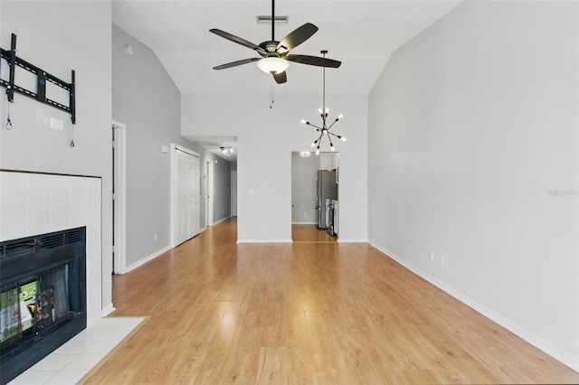 16109 Rambling Vine Dr E, Tampa, FL 33624 - unfurnished living room featuring a tile fireplace, high vaulted ceiling, ceiling fan, light wood-type flooring, and baseboards