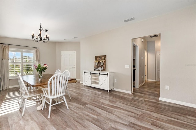 6050 Eagle Pointe Dr, Lakeland, FL 33812 - dining area with light wood finished floors, a chandelier, and baseboards
