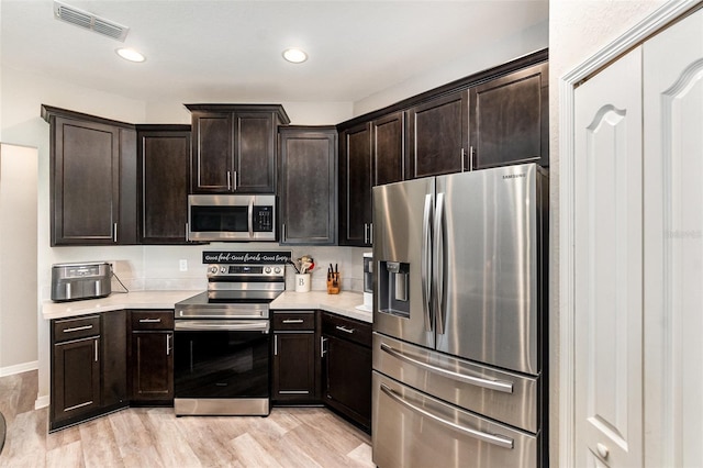 6050 Eagle Pointe Dr, Lakeland, FL 33812 - kitchen with appliances with stainless steel finishes, light countertops, light wood-style flooring, dark brown cabinets, and recessed lighting