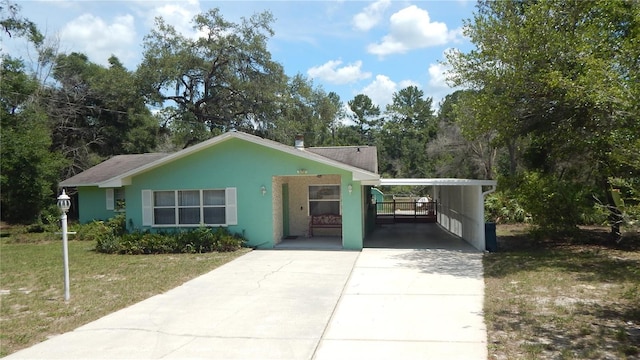 5287 Azalea Cir, Dade City, FL 33523 - view of front of property with an attached carport, concrete driveway, a front lawn, and stucco siding