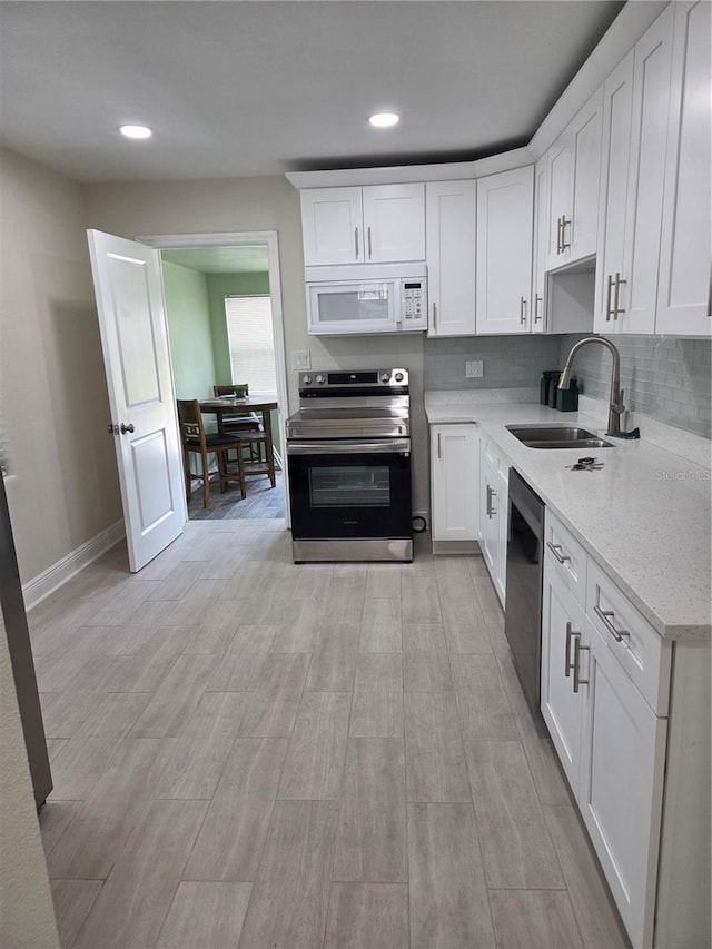 4611 17th Ave N, Saint Petersburg, FL 33713 - kitchen with stainless steel appliances, a sink, white cabinetry, baseboards, and recessed lighting