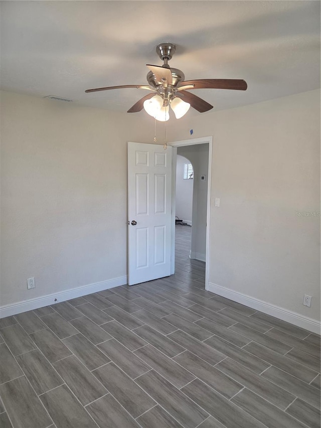 4611 17th Ave N, Saint Petersburg, FL 33713 - unfurnished room featuring ceiling fan, arched walkways, wood tiled floors, and baseboards