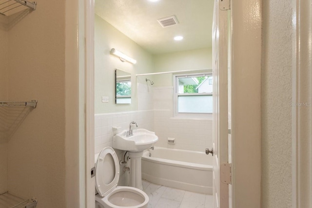 4611 17th Ave N, Saint Petersburg, FL 33713 - bathroom with bathing tub / shower combination, tile walls, marble look tile flooring, and wainscoting