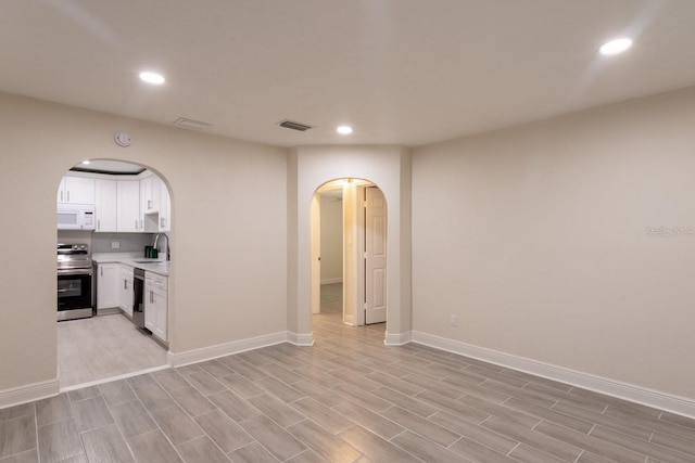 4611 17th Ave N, Saint Petersburg, FL 33713 - unfurnished living room featuring arched walkways, recessed lighting, and light wood-type flooring