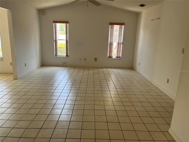 8130 Shalom Dr, Spring Hill, FL 34606 - empty room with ceiling fan, light tile patterned flooring, a textured ceiling, and vaulted ceiling